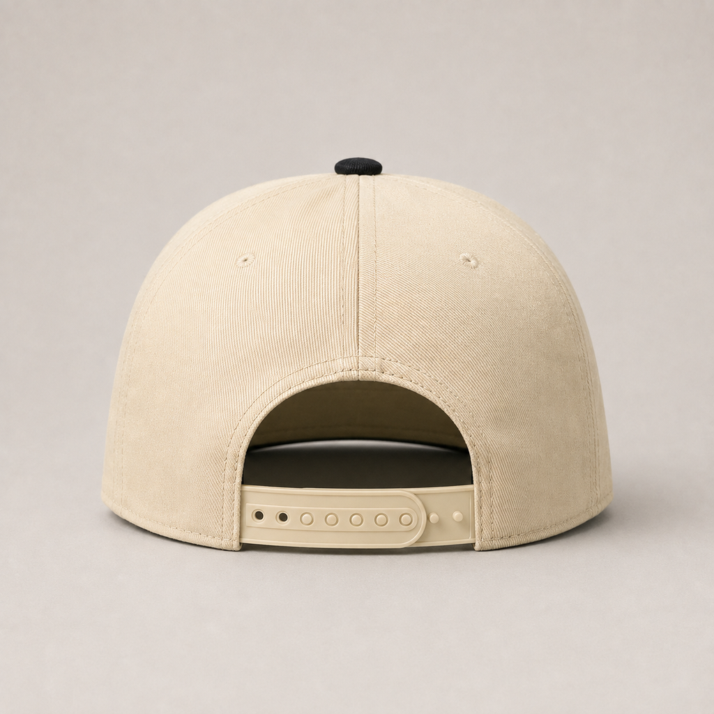 The back view of a beige baseball cap with an adjustable strap and a black button on top, set against a neutral gray background.